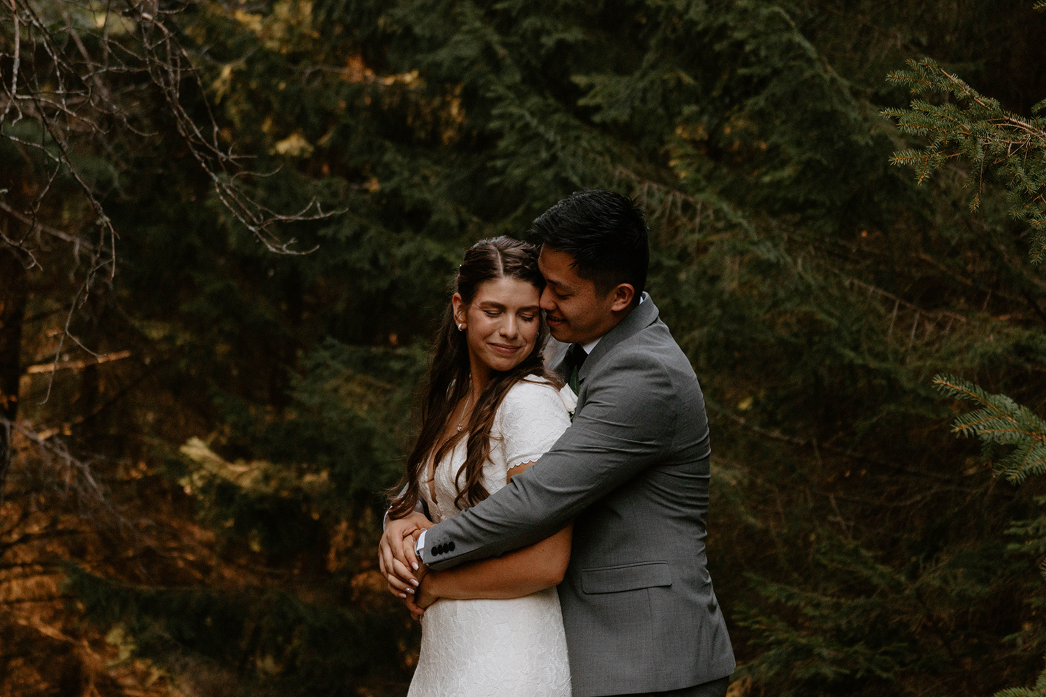 Couple celebrates wedding in northern michigan forest during backyard wedding.