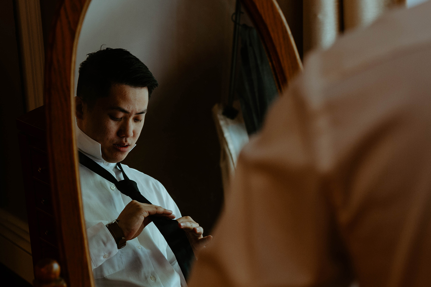 Groom getting ready before his wedding day ceremony in the woods.