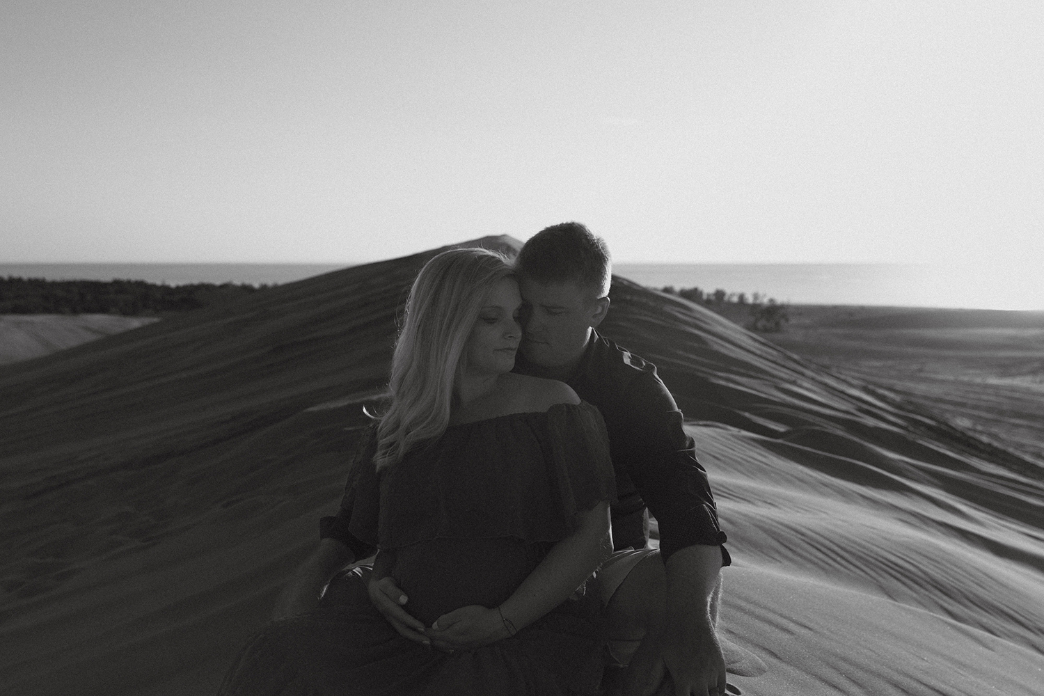Couple at Silver Lake Sand Dunes for maternity photos.