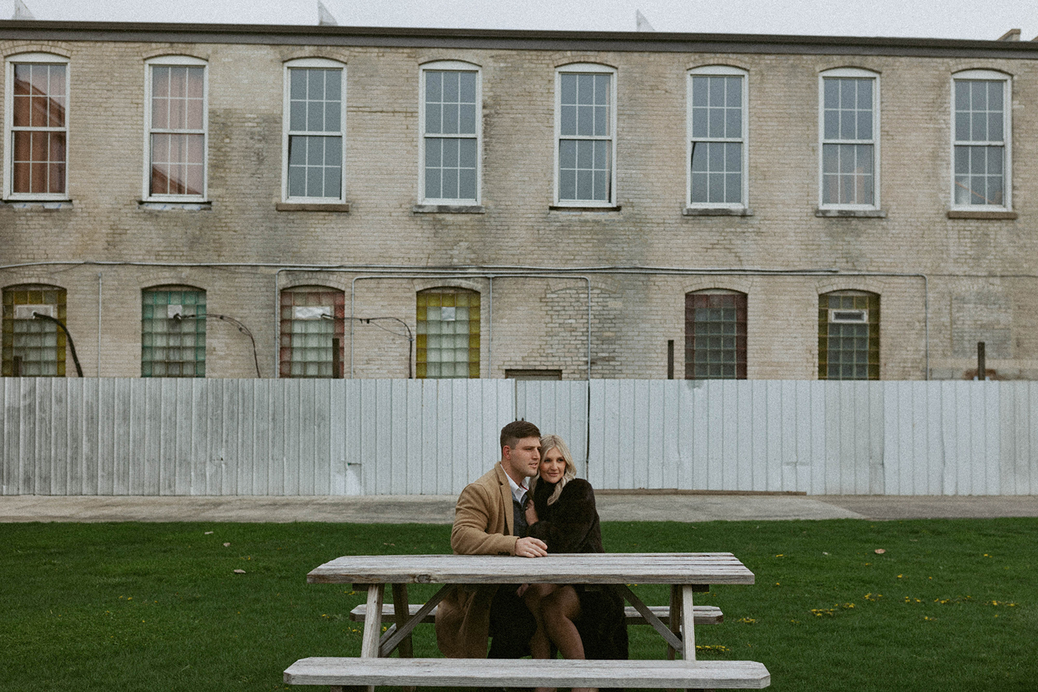 Couple shares a drink together outside Journeyman Distillery during engagement session.