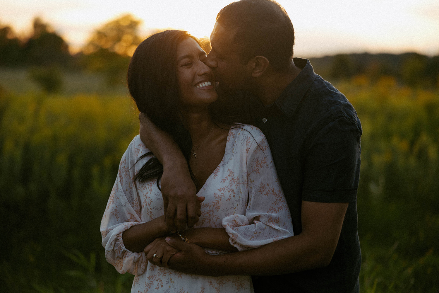 Couple snuggling together during their engagement session at Millennium Park in Grand Rapids, Michigan.