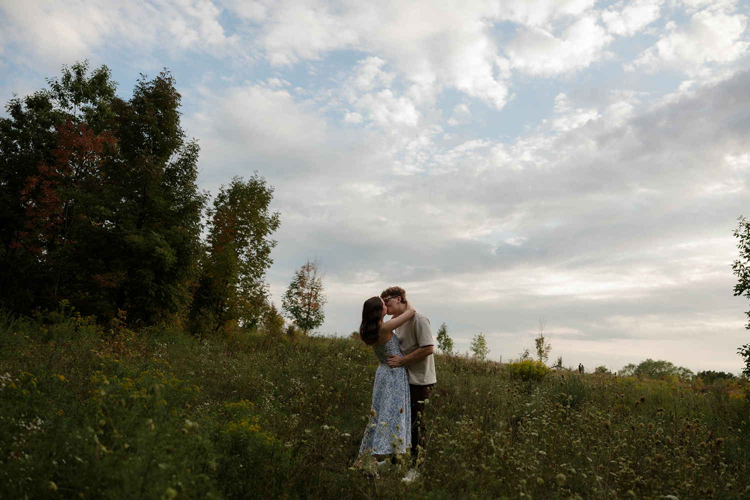 Couple kisses in a field at Grand Ravines Park in Jenison, Michigan.