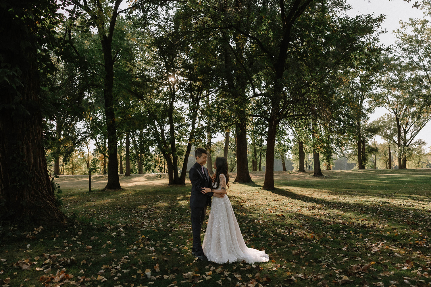 Couple in wedding attire taking bridal portraits at the park