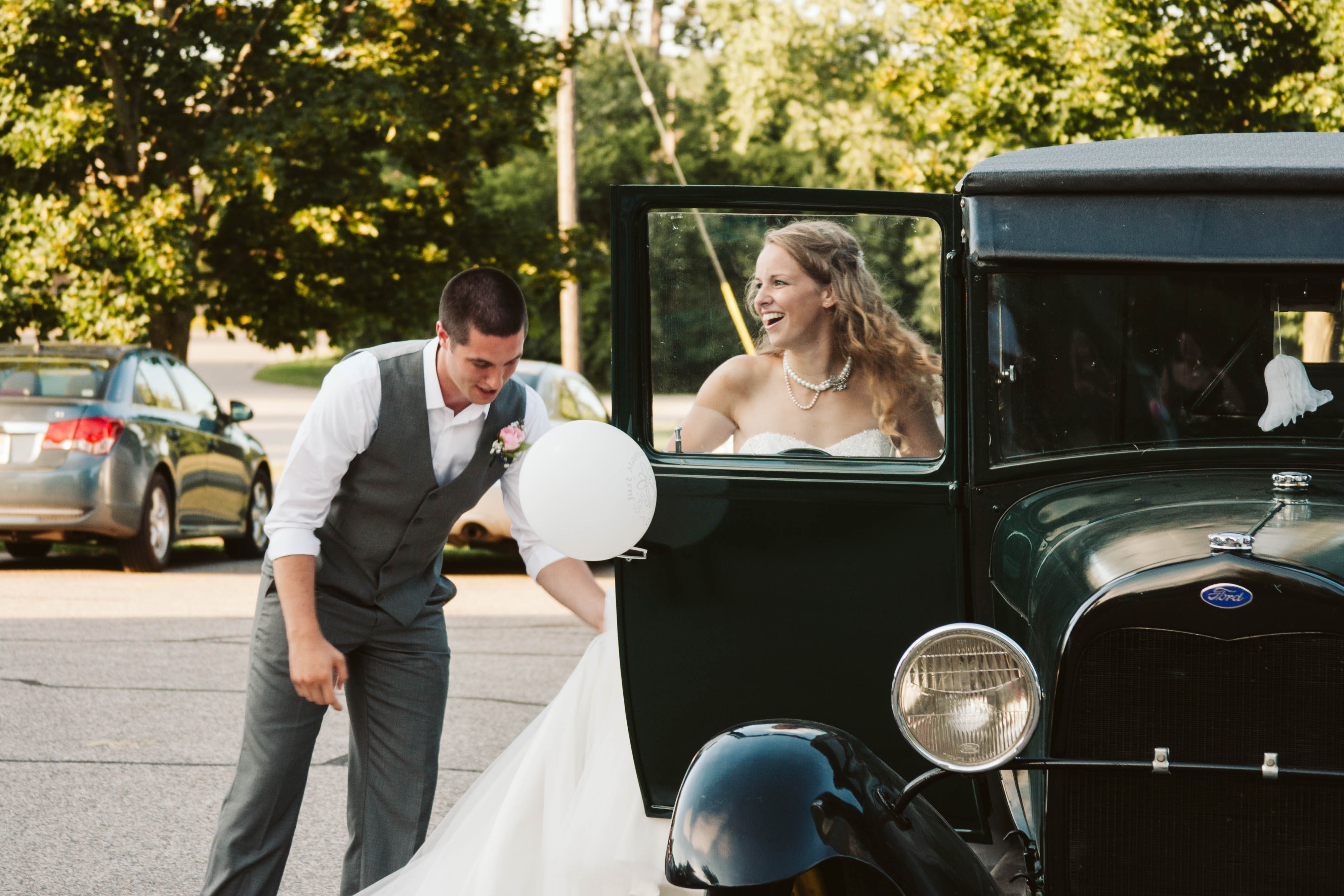 Couple drives off in vintage car to their wedding reception at Egypt Valley Country Club in Grand Rapids, Michigan.